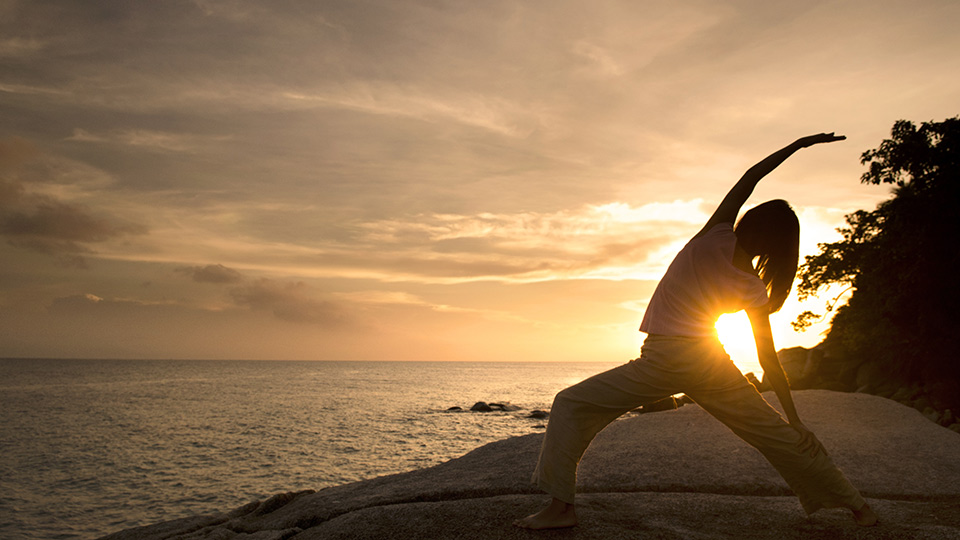 Woman doing yoga on a rock